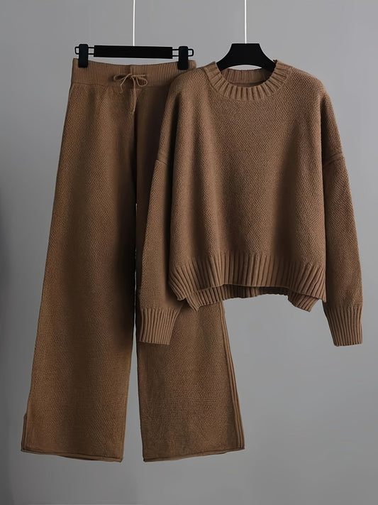 Brown knitted sweater and wide-leg pants set on hangers against a gray background